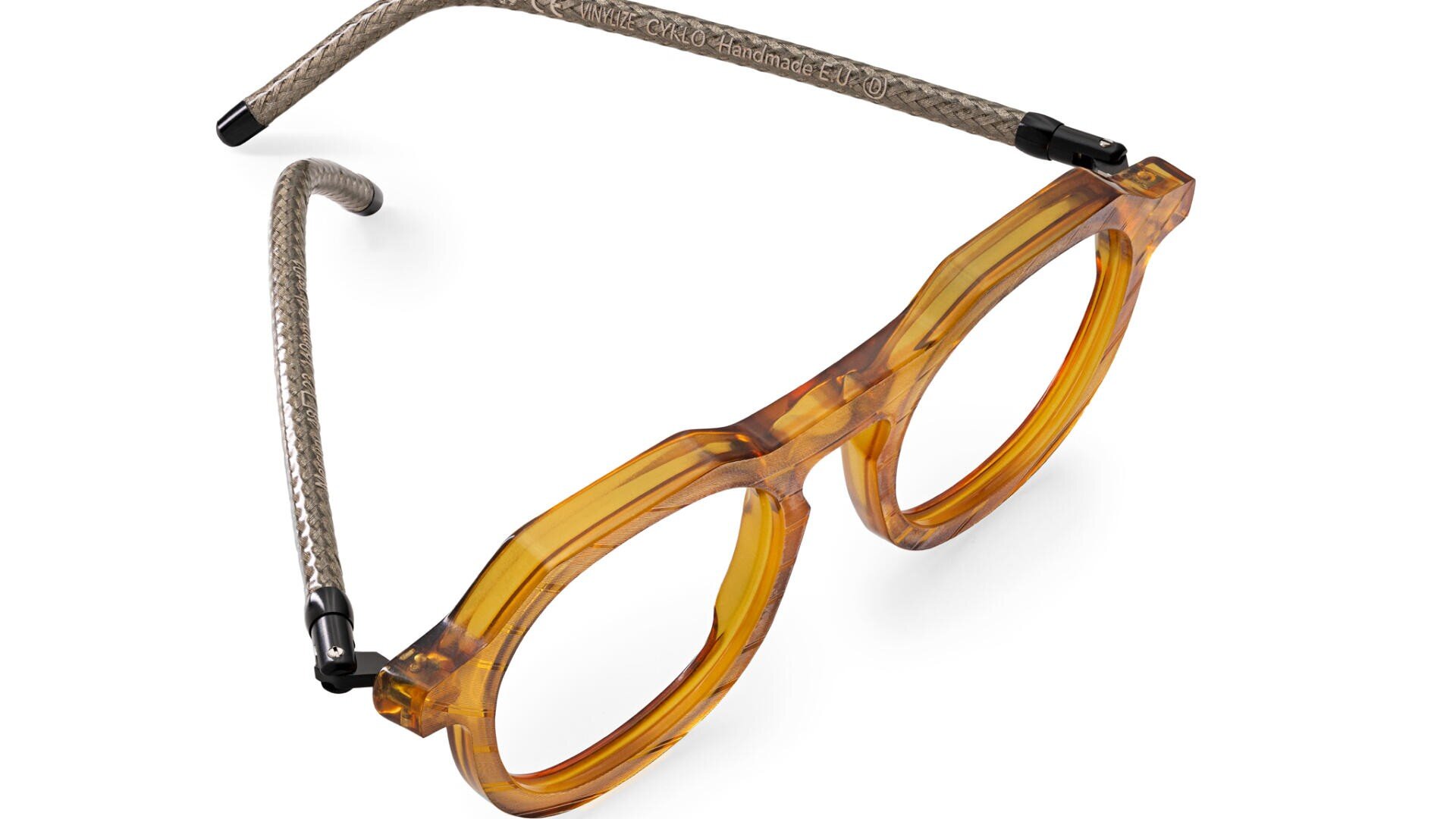 A pair of round, amber-colored eyeglasses with thick frames and woven, flexible temple arms, shown on a white background.