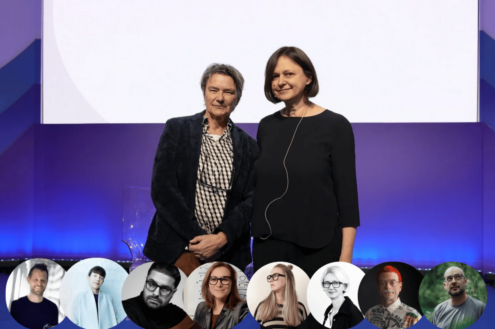 Zwei Personen stehen nebeneinander auf einer Bühne mit blauem und violettem Hintergrund. Unter ihnen befinden sich runde Porträts von acht Personen, die in einer Reihe angeordnet sind.