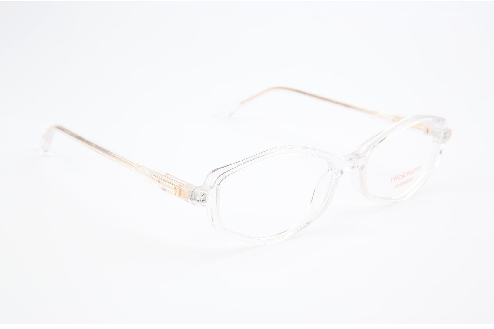 Clear, hexagonal eyeglasses with transparent frames and light gold arms are displayed on a white background. The brand name Hickmann is visible on one lens.