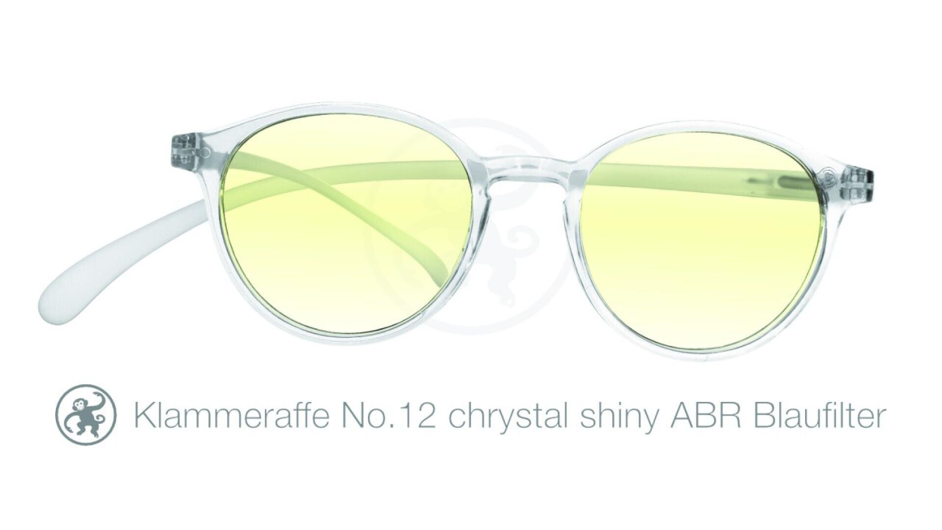 Transparente runde Brille mit hellgelben Gläsern. Darunter steht der Text: „Klammeraffe No.12 chrystal shiny ABR Blaufilter.“.