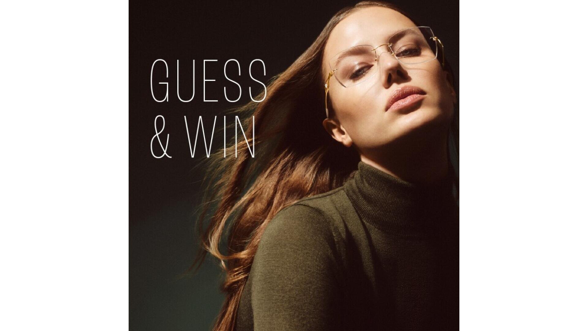 A woman with long brown hair wearing glasses and a dark green turtleneck poses confidently beside the text GUESS & WIN on a dark background.