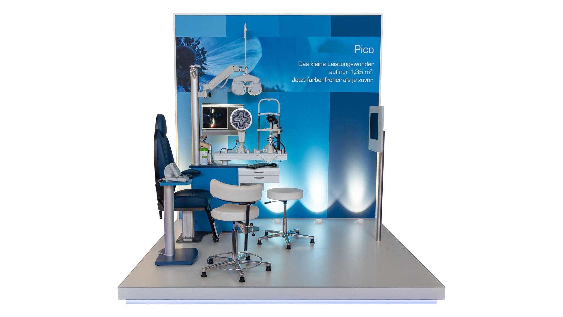 Eine ophthalmologische Untersuchungsstation mit einem blauen Untersuchungsstuhl, weißen Hockern, Augenuntersuchungsgeräten und einem blauen Hintergrunddisplay mit der Aufschrift "Pico" in deutscher Sprache auf einem erhöhten weißen Podest.