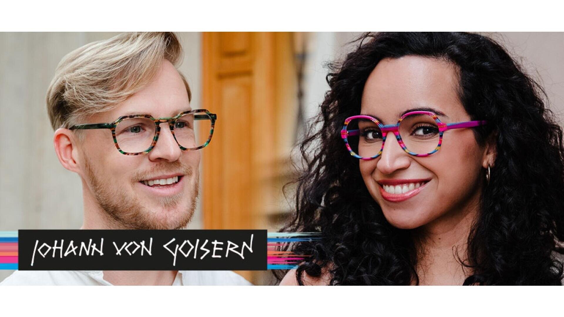 A man with light hair and a beard and a woman with curly dark hair both smile, wearing colorful eyeglasses. The text Johann von Goisern appears in a stylized font at the bottom left of the image.