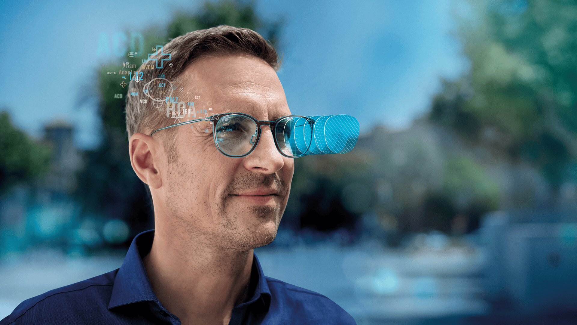 Ein Mann mit Brille blickt nach vorne, wobei blaue digitale Grafiken und Datenprojektionen über seinen Gläsern erscheinen, was auf Augmented-Reality- oder Smart-Glasses-Technologie hindeutet. Der Hintergrund ist unscharf und im Freien.