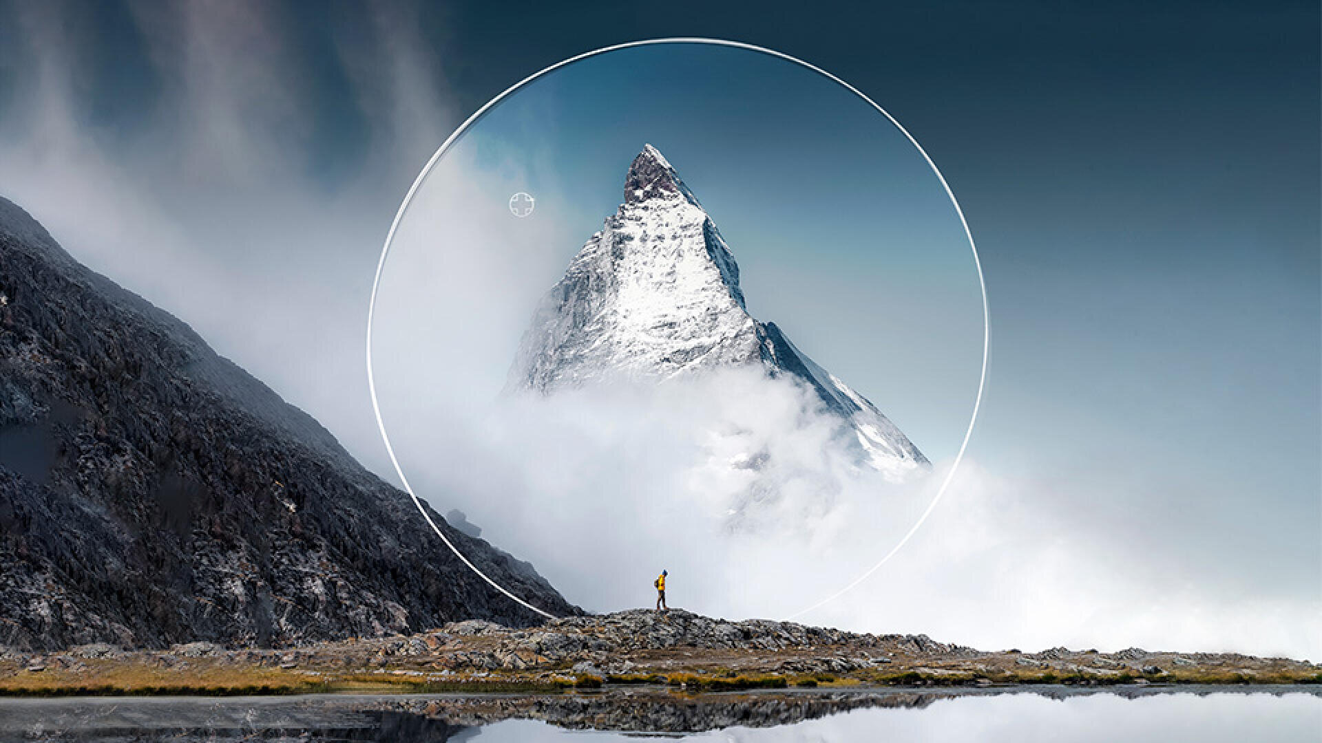 Eine einsame Person steht auf felsigem Grund und blickt auf einen schneebedeckten Berggipfel, der von Nebel umgeben ist. Ein weißer Kreis wird digital um den Gipfel herum vor einem klaren, dunklen Himmel eingeblendet.
