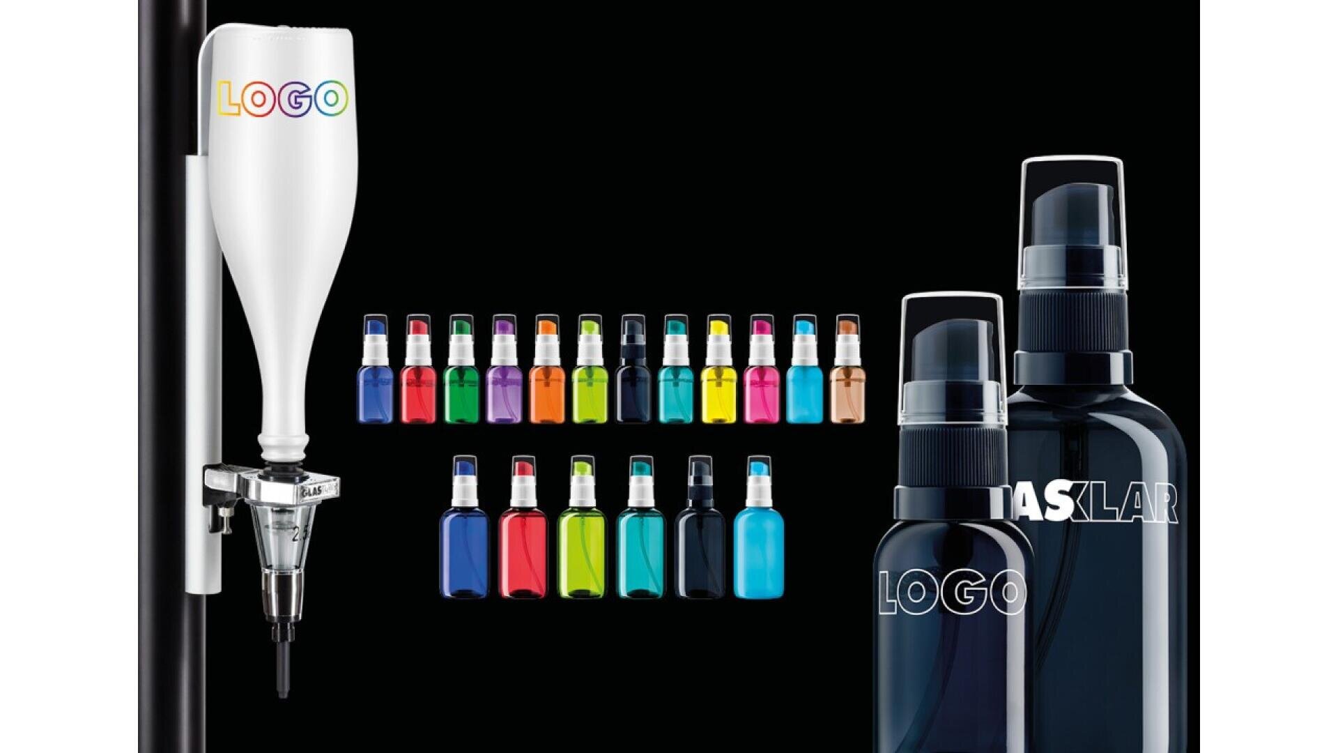 A white spray dispenser with a customizable logo is mounted on a pole, beside rows of colorful small spray bottles and two larger black spray bottles, all against a black background.
