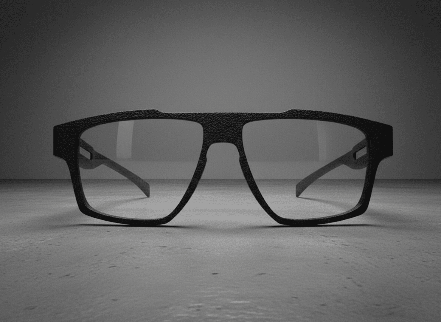 Modern black, rectangular glasses rest on a gray, flat surface with a simple color gradient in the background.
