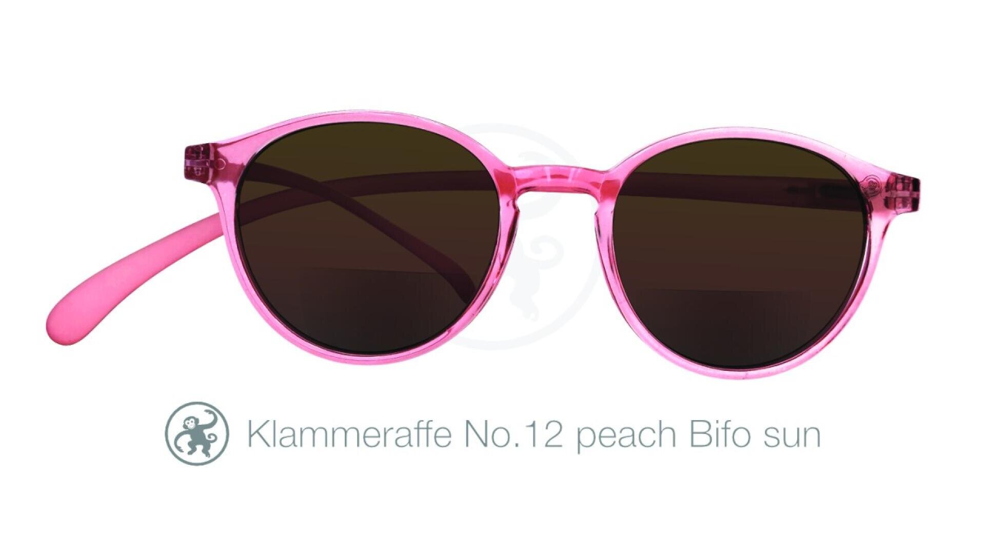 Rosa, runde Sonnenbrille mit dunklen Gläsern auf weißem Hintergrund. Der Text darunter lautet „Klammeraffe Nr. 12, pfirsichfarbene Bifo-Sonne“ mit einem kleinen Affensymbol links neben dem Text.