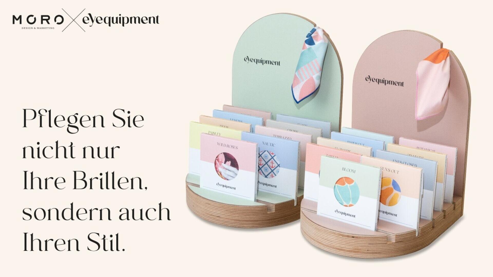 Two pastel display stands showcase colorful eyeglass cleaning cloths with various patterns. To the left, German text reads: Pflegen Sie nicht nur Ihre Brillen, sondern auch Ihren Stil.