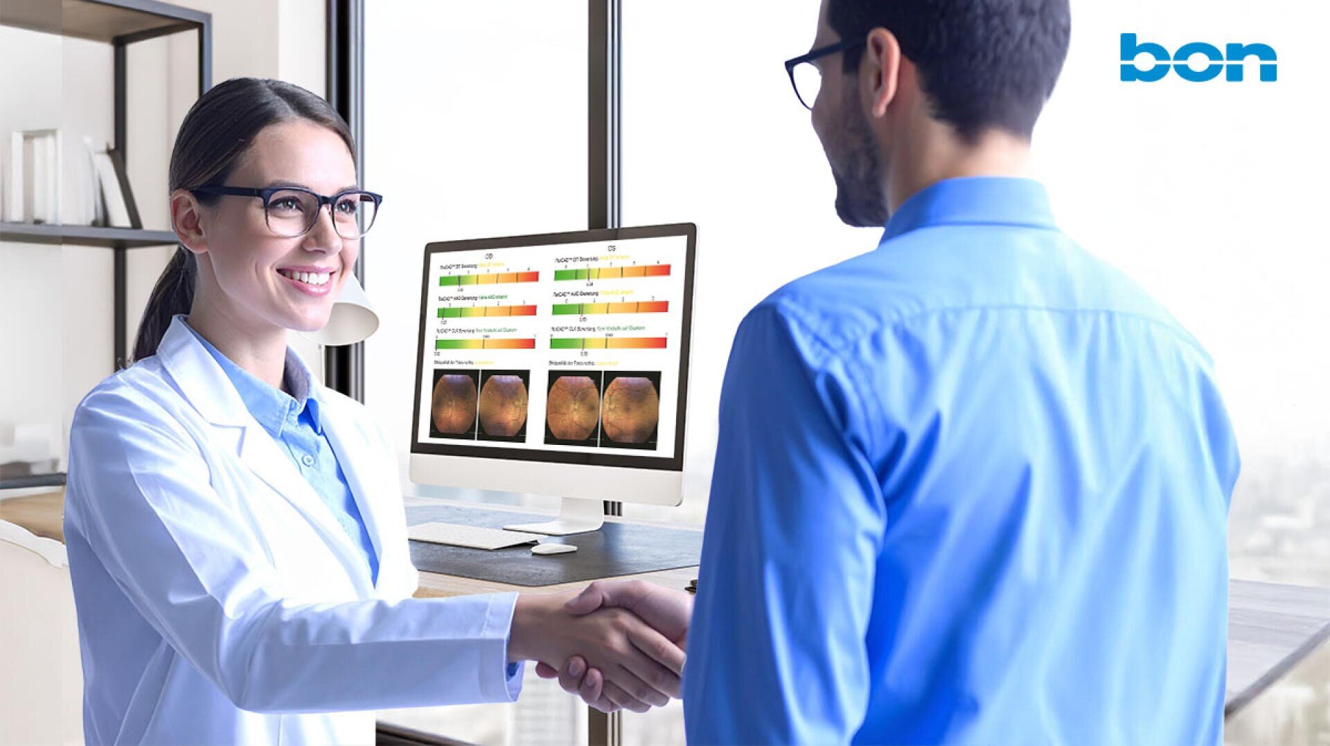 Eine Ärztin in einem weißen Kittel lächelt und schüttelt einem männlichen Patienten in einem Büro die Hand. Ein Computerbildschirm hinter ihnen zeigt bunte medizinische Testergebnisse und Bilder an. In der rechten oberen Ecke erscheint das Wort bon.