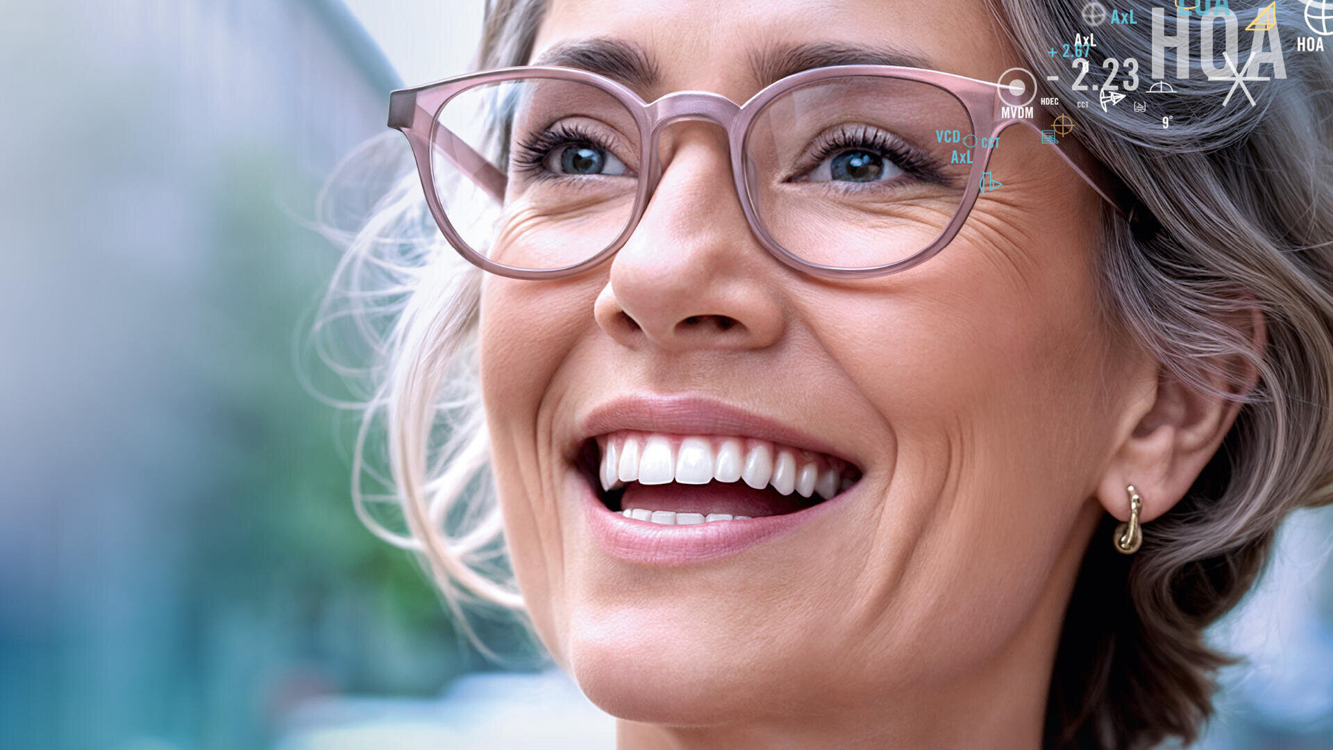 Eine lächelnde Frau mit kurzen grauen Haaren und Brille blickt in die Ferne. Sie trägt kleine Creolen und steht im Freien. Der Hintergrund ist unscharf, und in der oberen rechten Ecke sind digitale Grafiken eingeblendet.