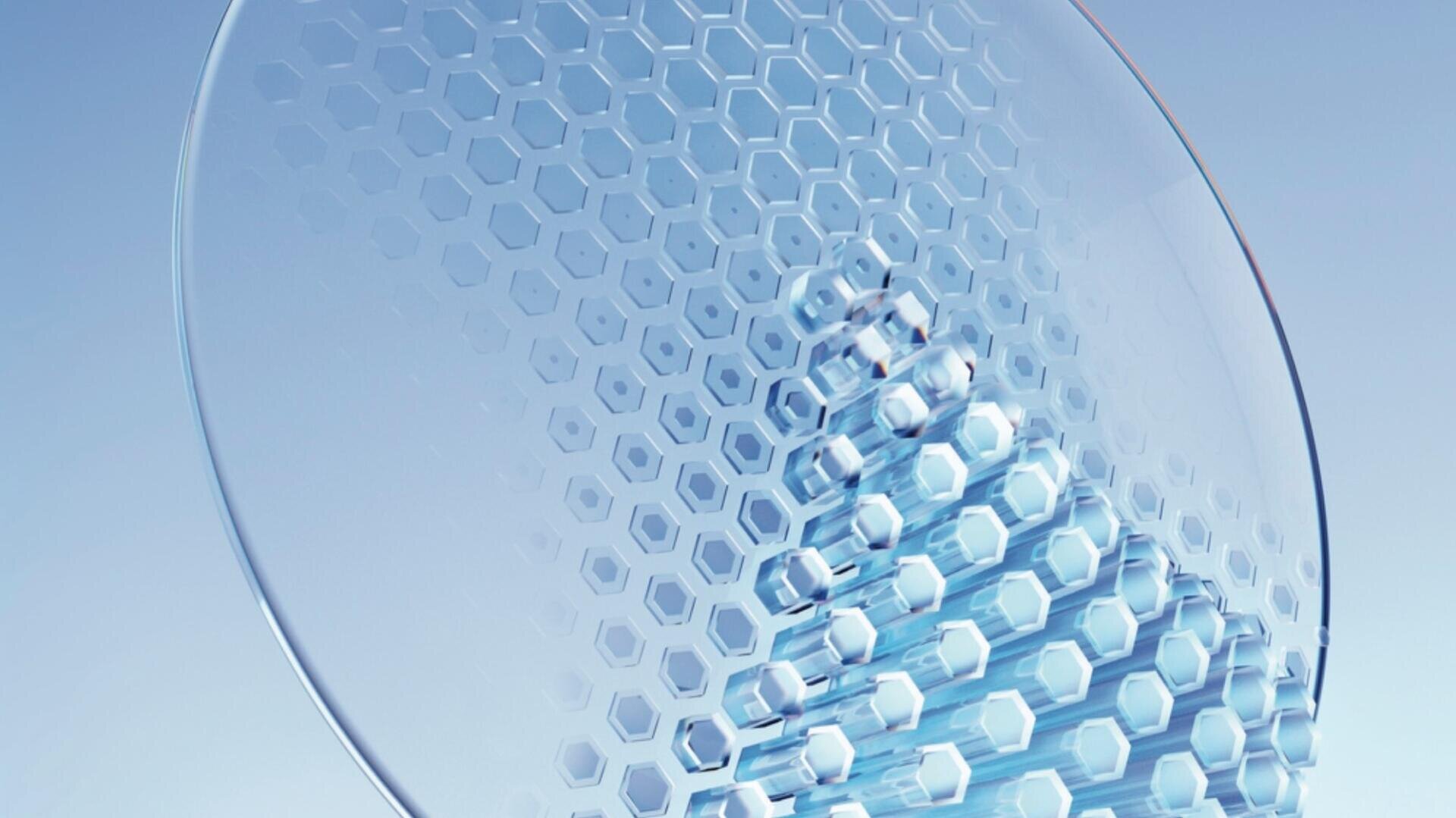 Nahaufnahme eines transparenten, kreisförmigen Objekts, möglicherweise eine Glas- oder Kunststoffscheibe, die ein sechseckiges Wabenmuster aufweist. Das Licht wird durch das Muster reflektiert und erzeugt weiche blaue und weiße Highlights auf einem hellen Hintergrund.