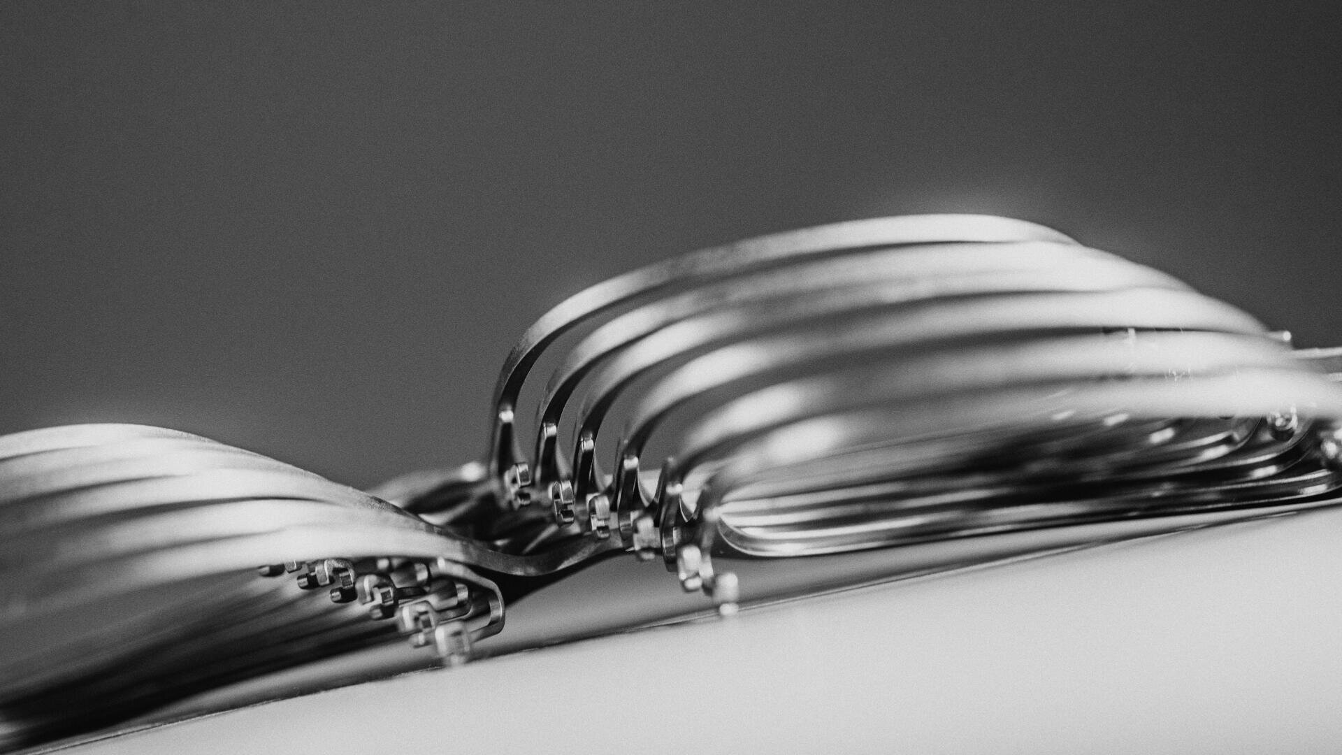 Ein Schwarz-Weiß-Foto in Großaufnahme von gestapelten Roh-Brillenfassungen.